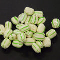 White candies with green stripes on a black background