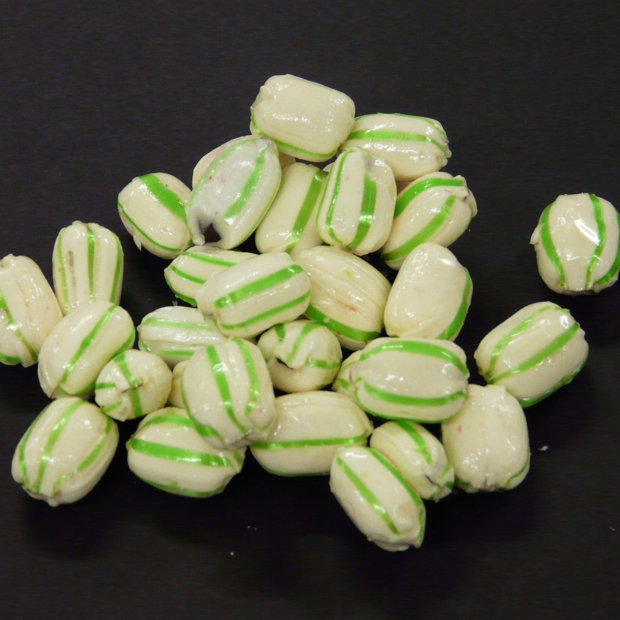 White candies with green stripes on a black background