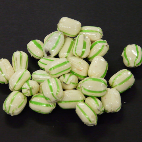 White candies with green stripes on a black background