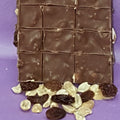 Chocolate bar with visible squares on a purple background