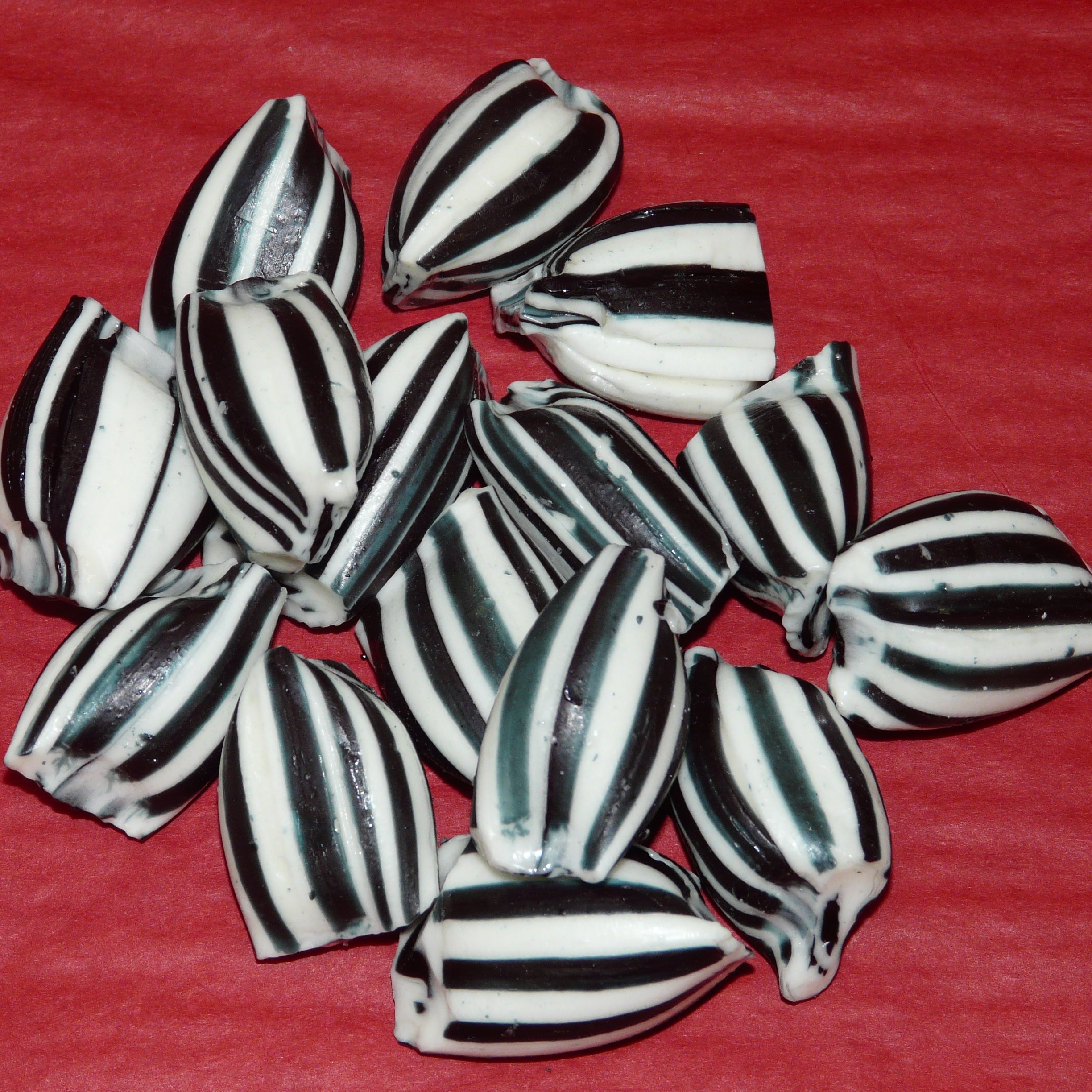 Black and white striped candies on a red background