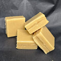 Four square pieces of fudge on a dark gray background