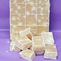 Block of fudge cut into squares on a purple background