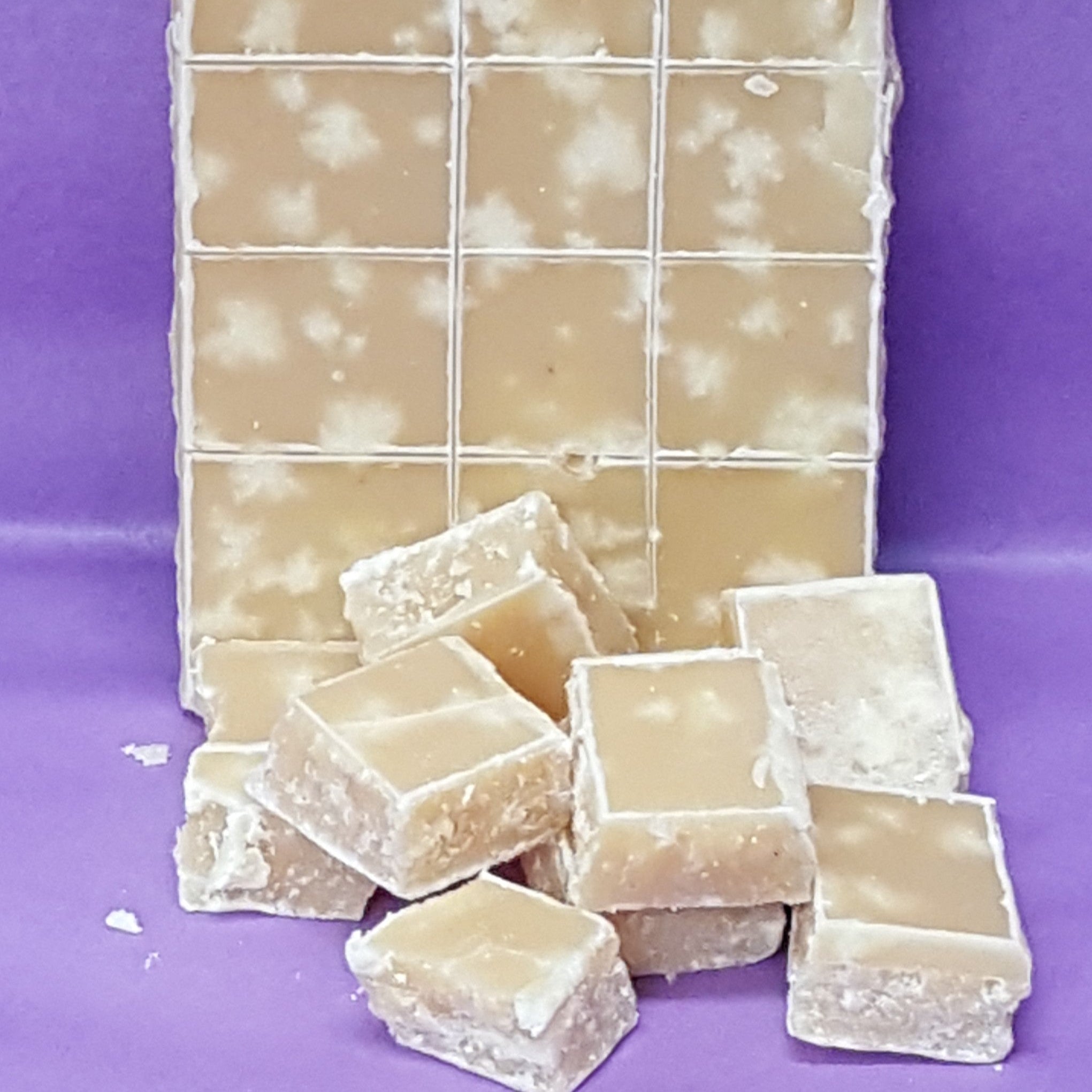 Block of fudge cut into squares on a purple background