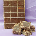 Stack of chocolate bars with a few pieces on a purple background