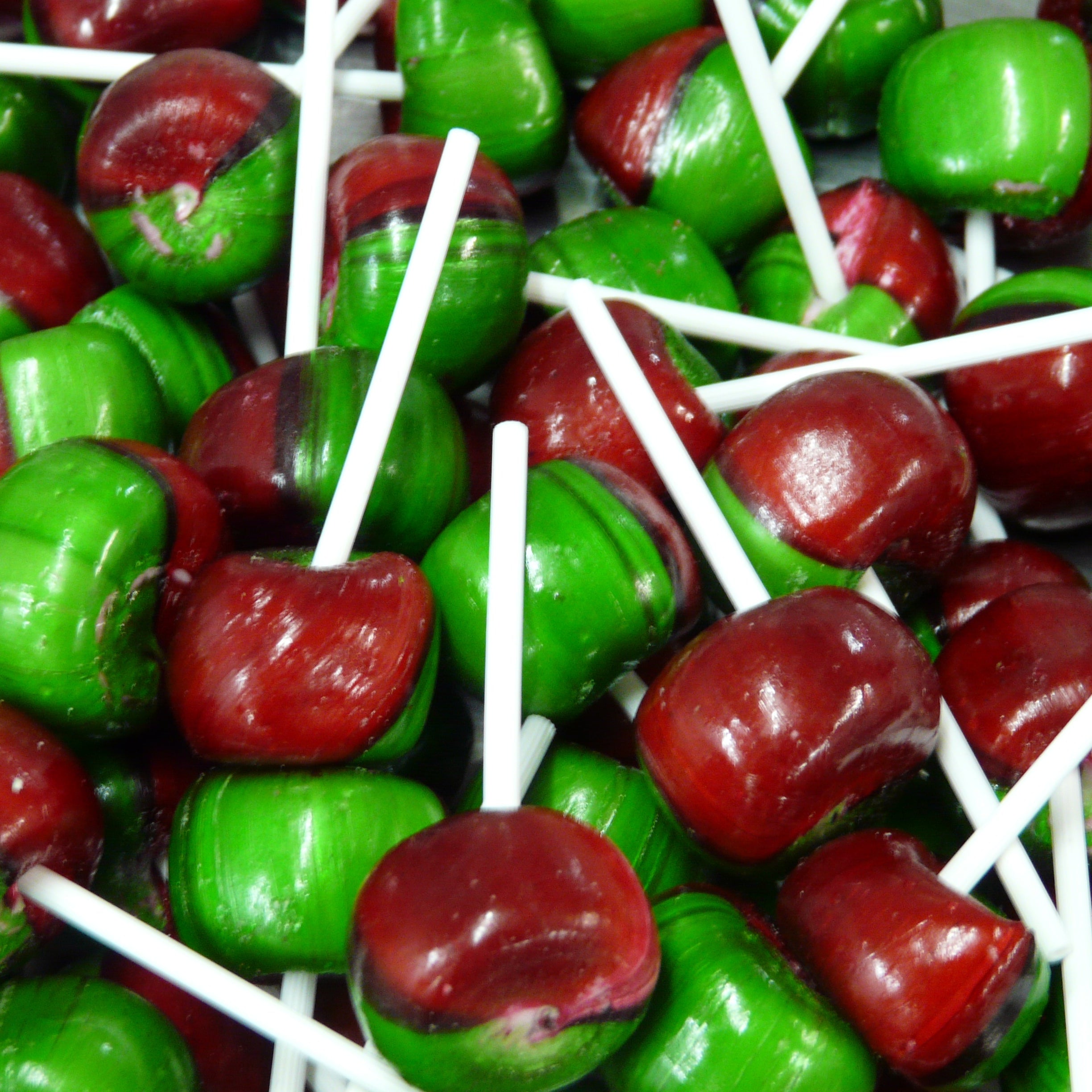 Assorted red and green lollipops on sticks.