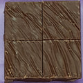 Chocolate bar cut into four pieces on a purple background